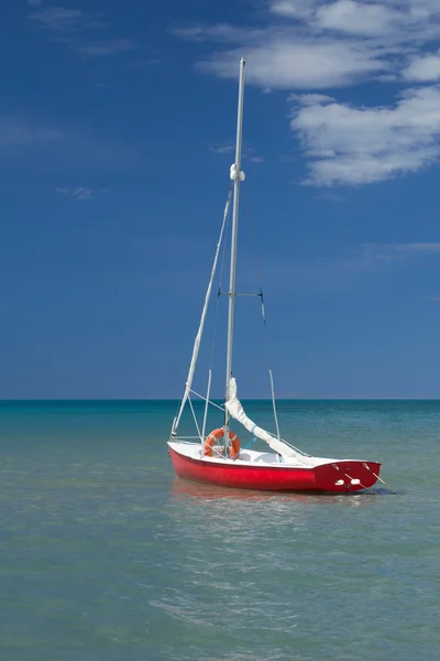 Yalnız kırmızı ve beyaz denizde (dikey olarak tekne) — Stok fotoğraf