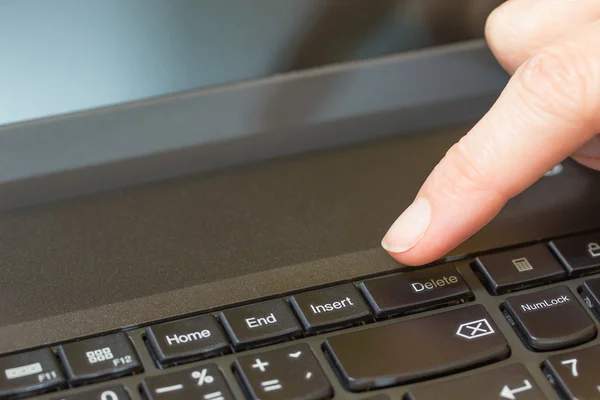 Pressionando a tecla Excluir no teclado de um laptop — Fotografia de Stock