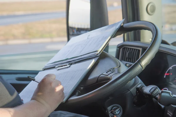 Motorista de caminhão está escrevendo na ocumentação . — Fotografia de Stock