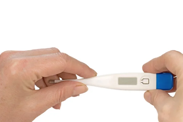 Woman is holding in both hands a digital thermometer — Stock Photo, Image