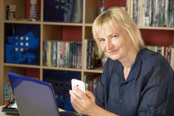 De vrouw van middelbare leeftijd op kantoor aan huis — Stockfoto