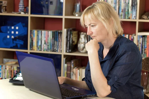 Midden leeftijd vrouw werkt vanuit een huis — Stockfoto