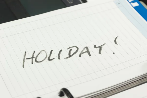 Открыть страницу дневника бумажных менеджеров с надписью HOLIDAY — стоковое фото