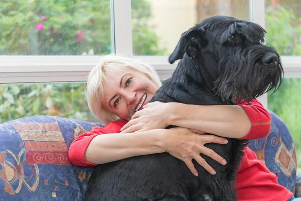 Blondine mittleren Alters umarmt den Hund — Stockfoto