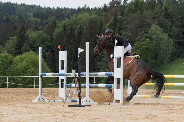 Amazone is het beheersen van een weerspannige bruin paard — Stockfoto