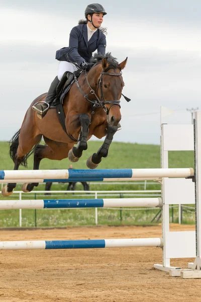 Horsewoman in high jump over a obstacle. Vertically. — Stock Photo, Image