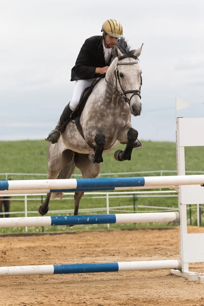 Vue rapprochée du cavalier en veste rouge sur un cheval blanc — Photo