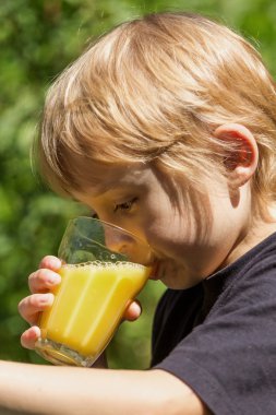 Küçük sarışın çocuk suyu içiyor