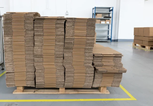 Front view of folded cardboard boxes in assembly hall — Stock Photo, Image