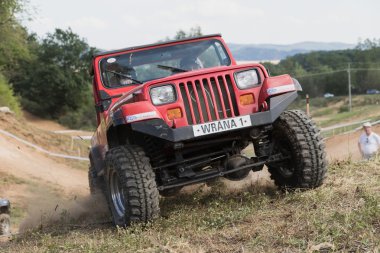 Closeup front view of a red off road car in terrain