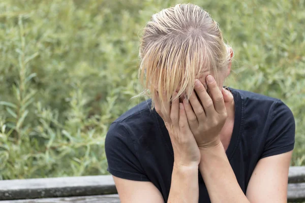 Middle aged woman is covering her face by hand — Stock Photo, Image