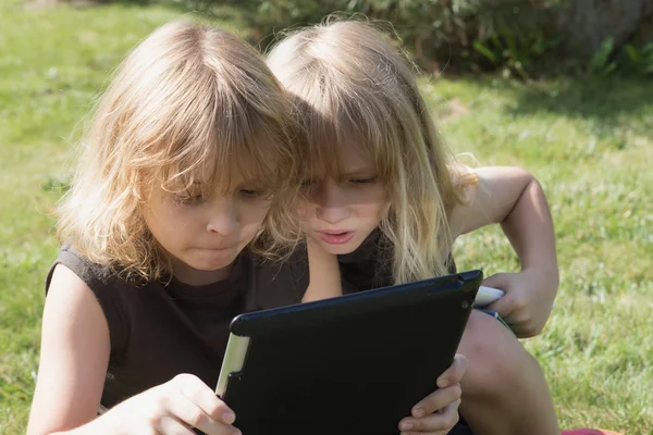 Dos chicos están mirando a la tableta al aire libre —  Fotos de Stock