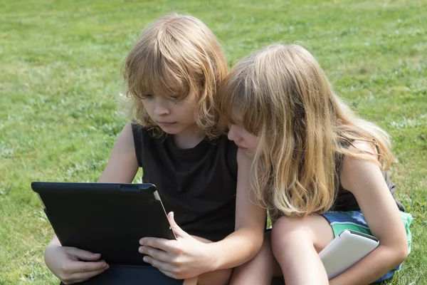 Los chicos rubios con tabletas están al aire libre —  Fotos de Stock