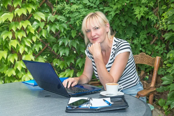 Pensive blonde middle aged woman is sitting in outdoor office — Stock Photo, Image
