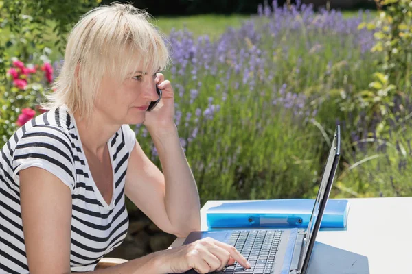 Side view of blonde woman calling outdoors — Stock Photo, Image