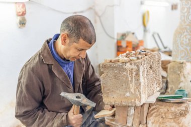 Fez, Fas, 21 Nisan 2024: Küçük seramik fayanslar üreten zanaatkar işçi 