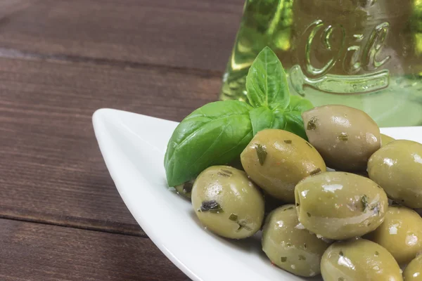 Gröna oliver med på personalen i trä — Stockfoto