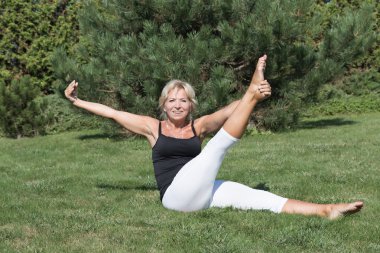 Kadın kıdemli egzersiz ve kameraya bakıyor