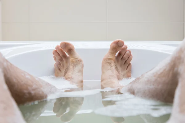 Pieds d'homme dans une baignoire, accent sélectif sur les orteils — Photo