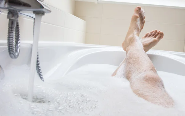 Pieds d'homme dans une baignoire, accent sélectif sur les orteils — Photo