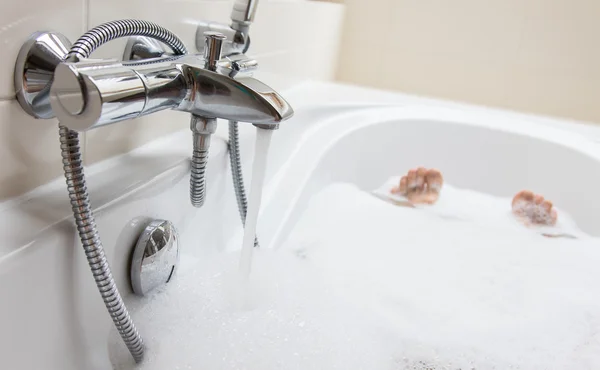Mäns fötter i ett badkar, selektiv inriktning — Stockfoto