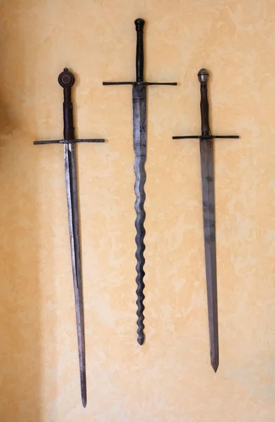 Ancient swords mounted on a yellow wall