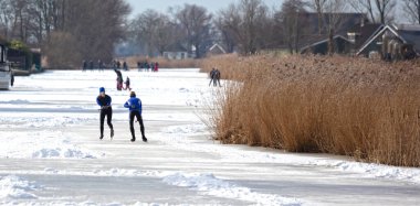 Çift, Hollanda 'da kış aylarında buzda kayıyor.