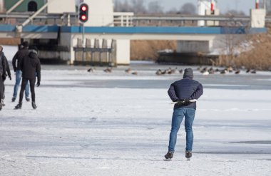 Yalnız adam doğal buzda kayıyor, Hollanda 'da kış.