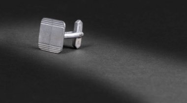 Eski gümüş kol düğmesi, koyu arkaplanda izole (gölgeli))