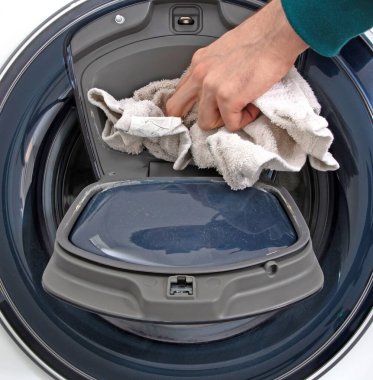 Çamaşır makinesini dolduran adam, temizlik zamanı.