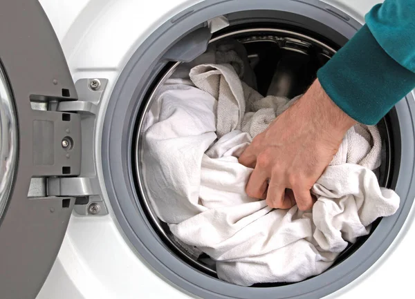 Man filling laundry in the washing machine, cleaning time