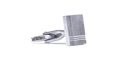 Beyaz arka planda izole edilmiş eski gümüş kol düğmesi.