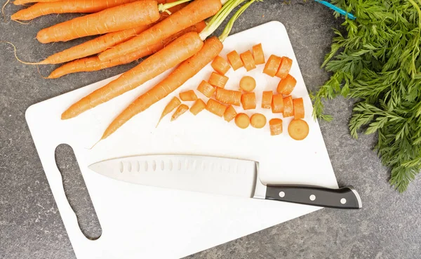 Cutting board with carrots and a sharp knife - Concept of food