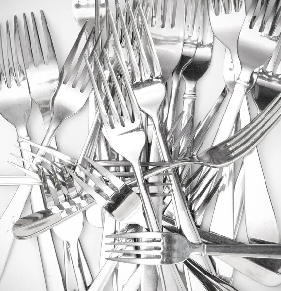 Pile of old metal forks, isolated on white