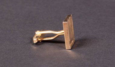 Eski yaldızlı kol düğmesi, koyu arkaplanda izole edilmiş (gölgeli))