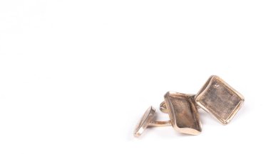 Eski yaldızlı kol düğmeleri, beyaz arka planda izole edilmiş.