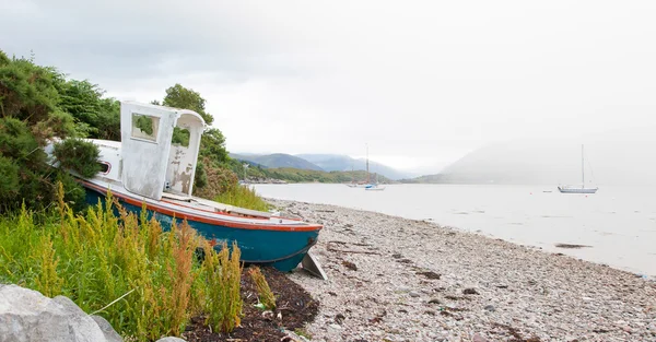 Loch taş plajı ile küçük gemi enkazı — Stok fotoğraf
