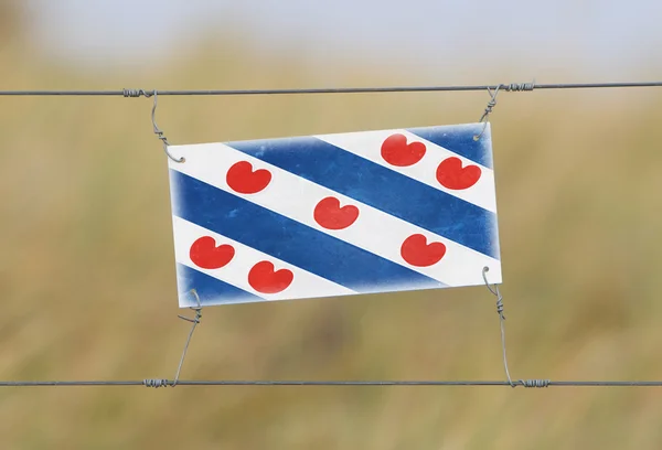 Stängsel - gammal plast tecken med en flagga — Stockfoto