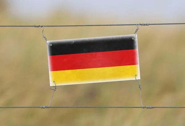 Borderhekje - oude plastic bord met een vlag — Stockfoto