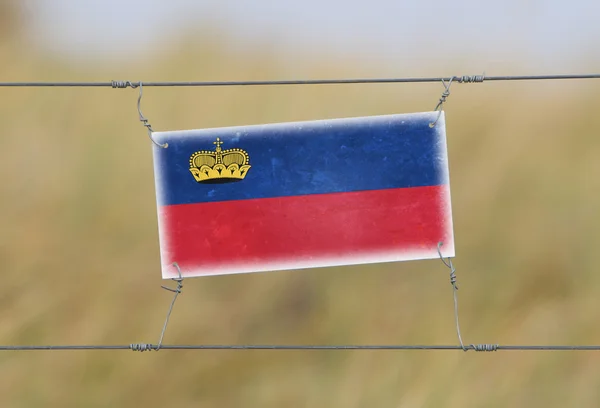 Recinzione di confine - Vecchio segno di plastica con una bandiera — Foto Stock