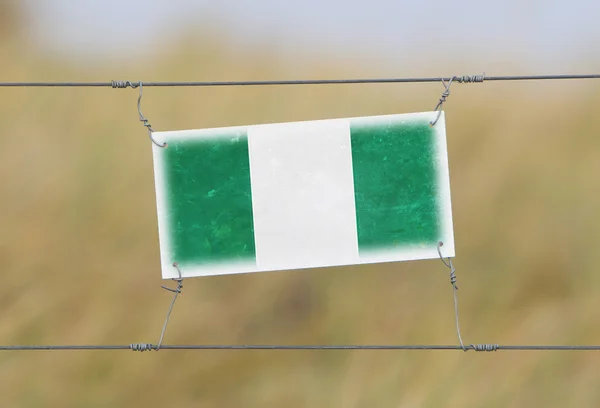 Recinzione di confine - Vecchio segno di plastica con una bandiera — Foto Stock