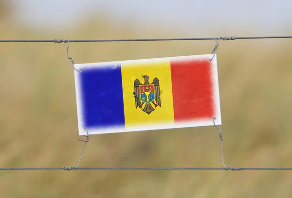 Clôture frontalière - Vieux panneau en plastique avec un drapeau — Photo