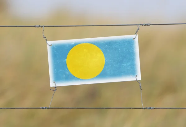 Cerca de fronteira - Plástico antigo com uma bandeira — Fotografia de Stock