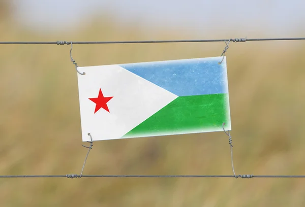 Valla fronteriza - Antiguo letrero de plástico con bandera —  Fotos de Stock