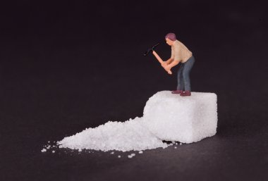 Miniature worker working on a sugar cube clipart