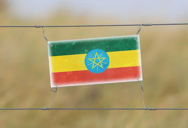 Borderhekje - oude plastic bord met een vlag — Stockfoto