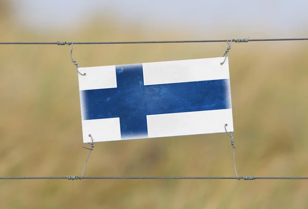 Clôture frontalière - Vieux panneau en plastique avec un drapeau — Photo