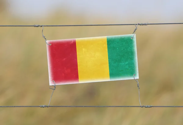 Valla fronteriza - Antiguo letrero de plástico con bandera —  Fotos de Stock