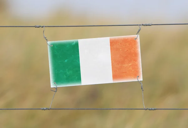 Пограничный забор - старый пластиковый знак с флагом — стоковое фото