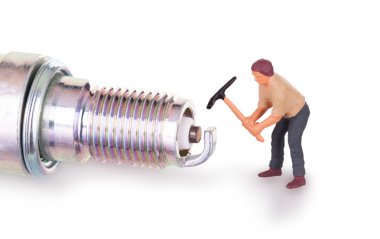 Miniature worker working on a sparkplug clipart